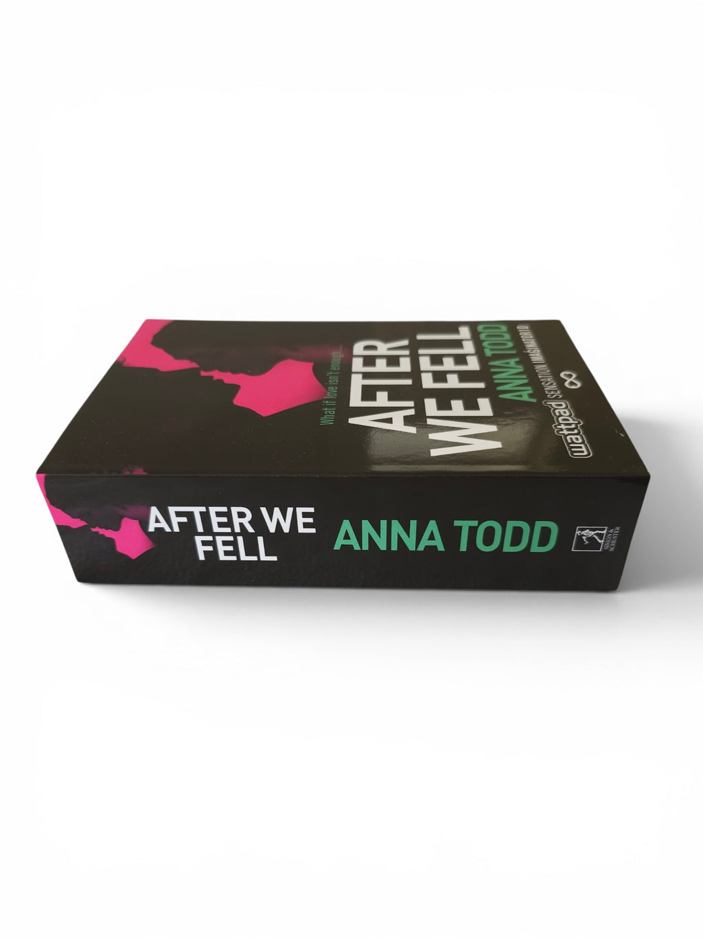 A book titled 'After We Fell' by Anna Todd, shown at an angle on a clean white background. The cover is predominantly black with pink graphic accents, white title text, and green author text.