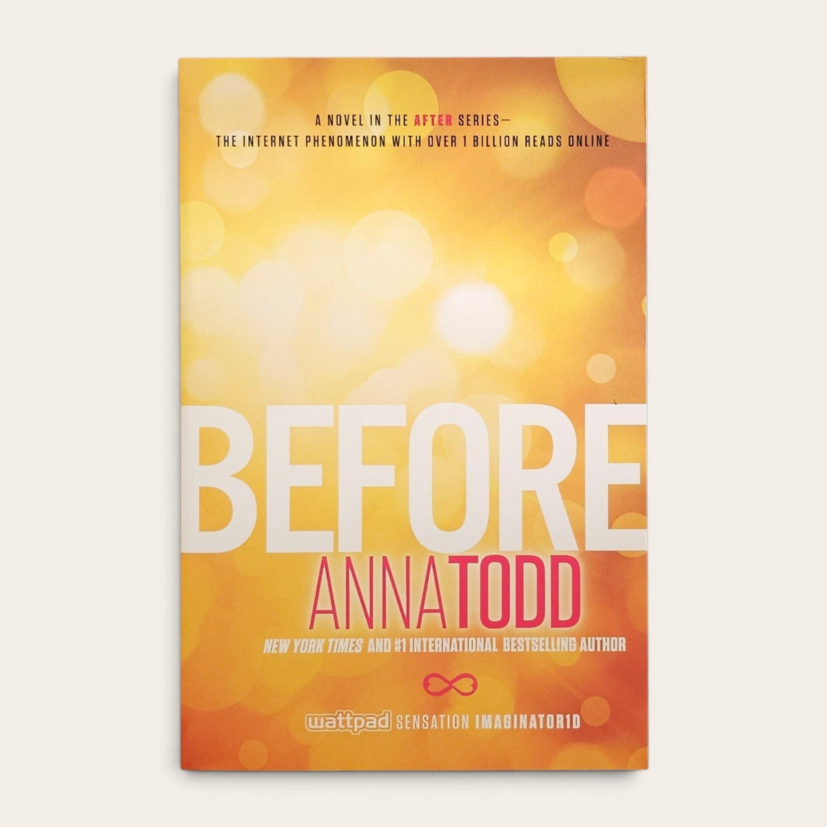 Book cover for 'Before' by Anna Todd, featuring a warm yellow and orange bokeh background with large white title text and pink author name.
