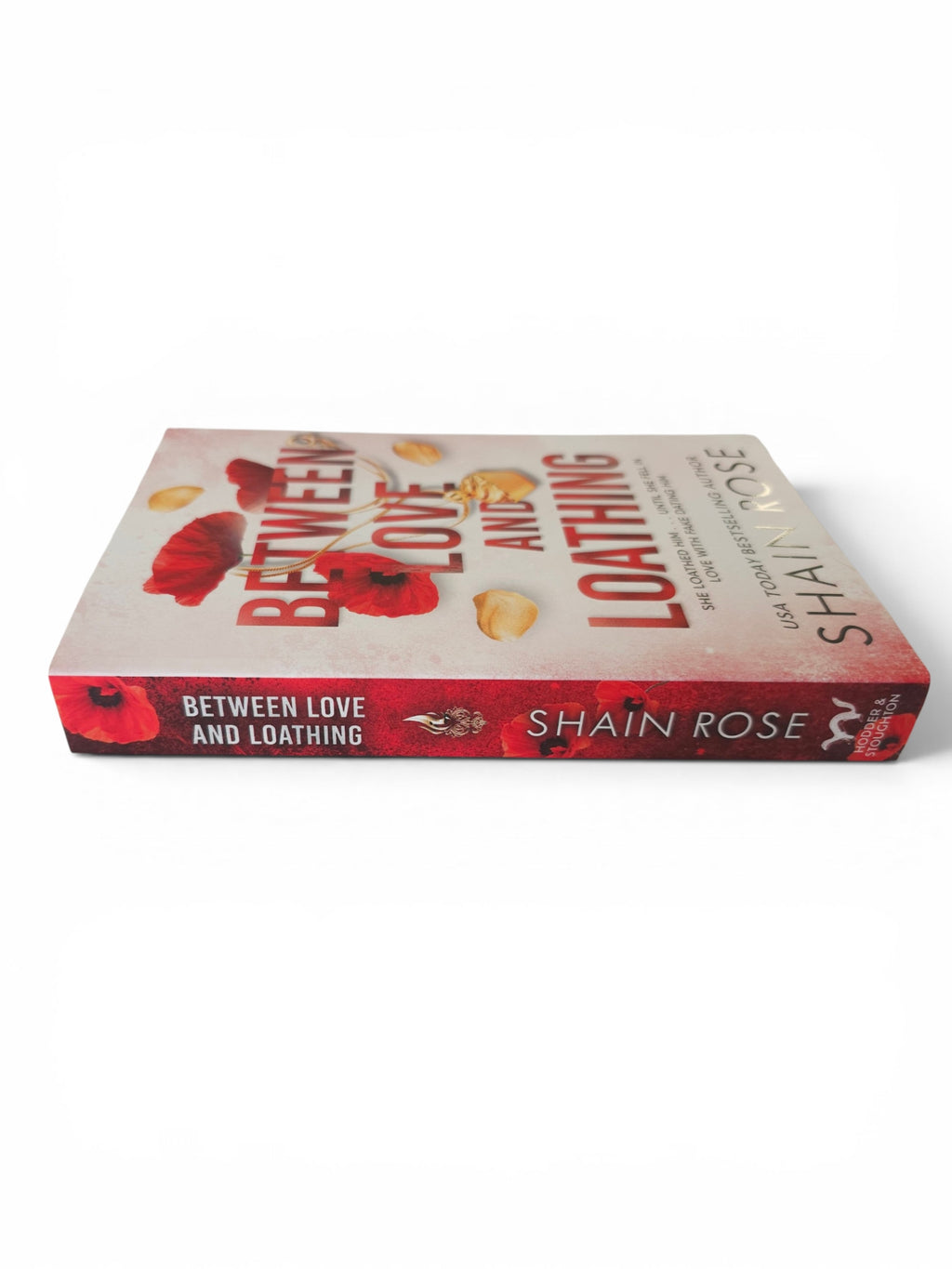 A paperback book titled 'Between Love and Loathing' by Shain Rose, displayed at an angle on a clean white background.
