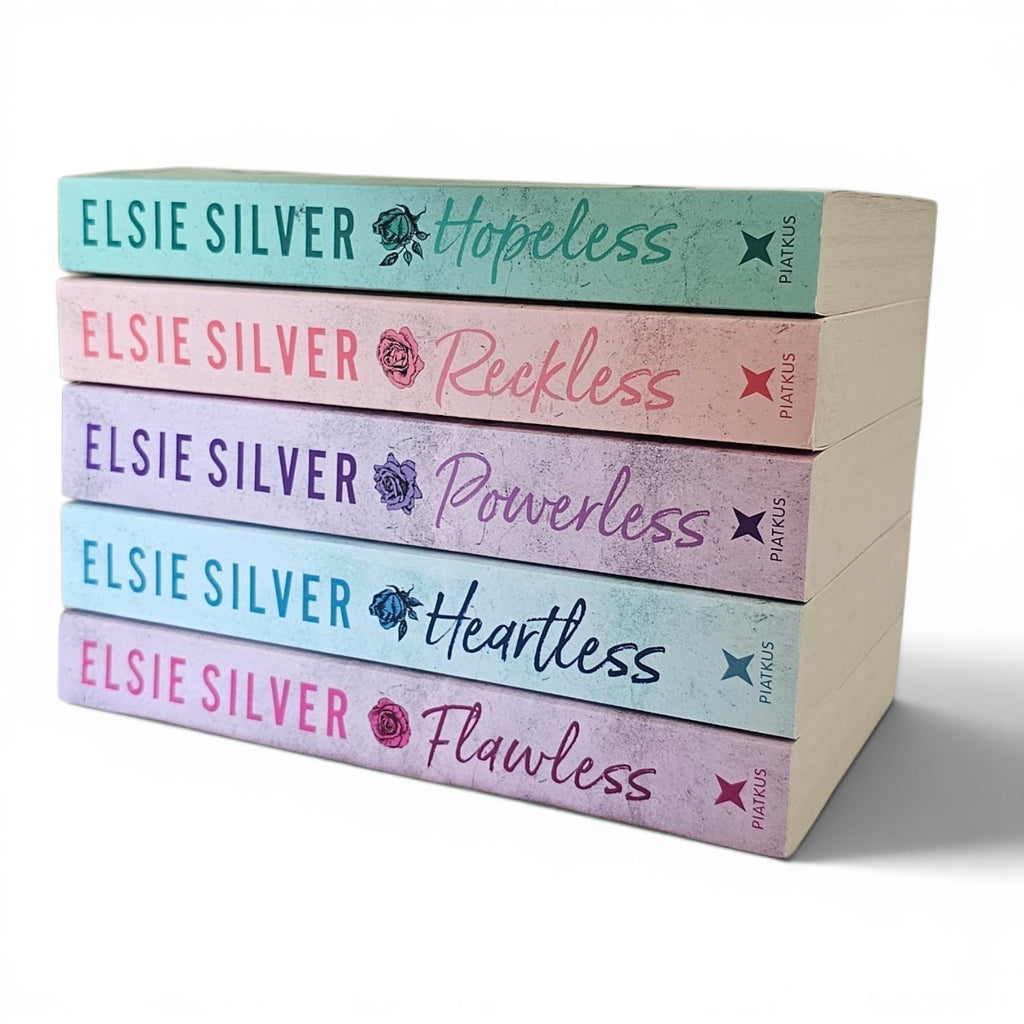 A stack of paperback books by Elsie Silver. Her chestnut springs series including, Flawless, Heartless, Powerless, Reckless, Hopeless. On a clean white background. Cowboy small town spicy romance.