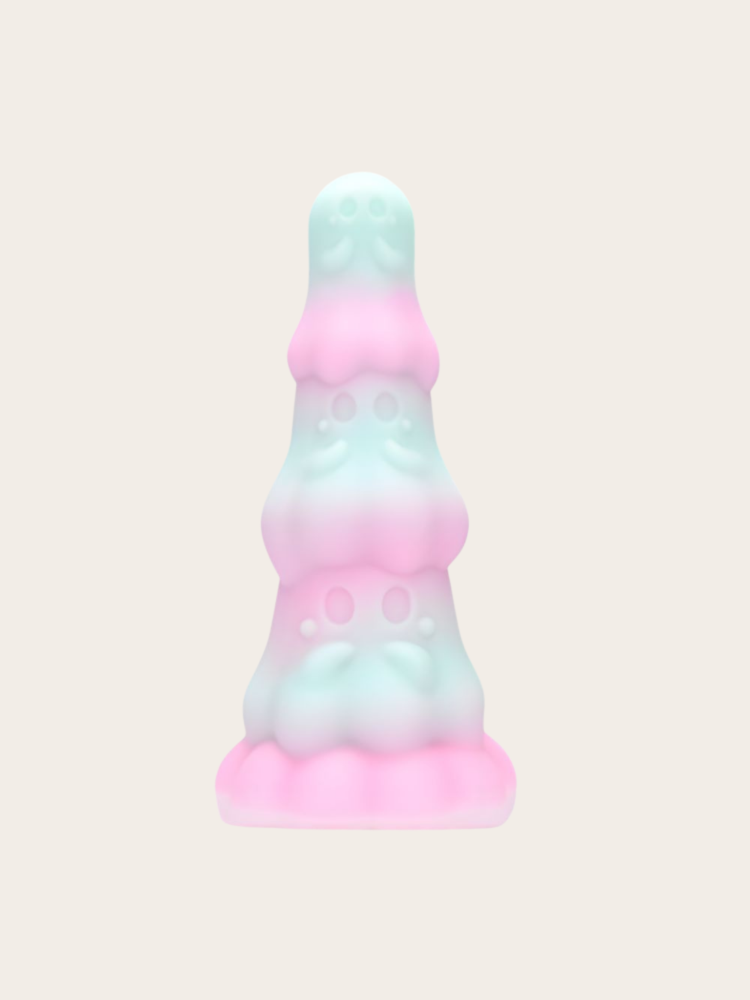 A pastel-colored, tiered ghost-shaped dildo with a pink and mint green gradient, centered on a solid light beige background.