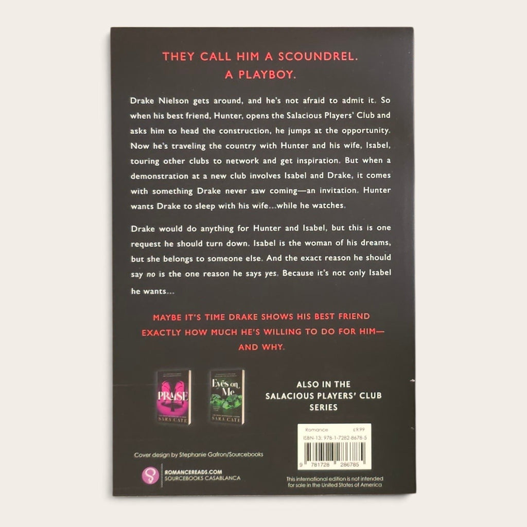 The back cover of a book, photographed flat against a white background. The cover is dark gray with red and white text, featuring the title 'Give Me More by Sara Cate