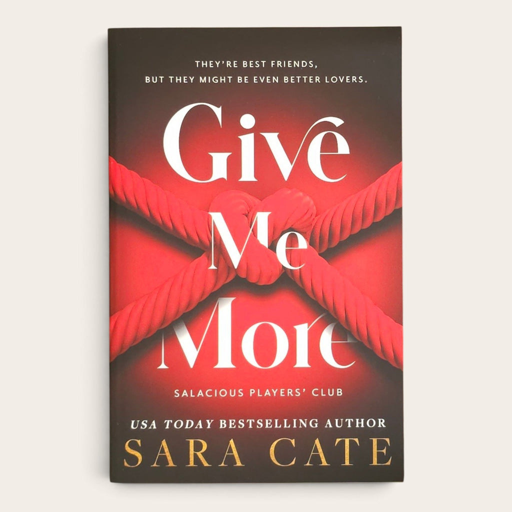 The book cover of 'Give Me More' by Sara Cate, featuring a dark brown and red background with a red rope knot design and white and gold text, shown on a light beige background.