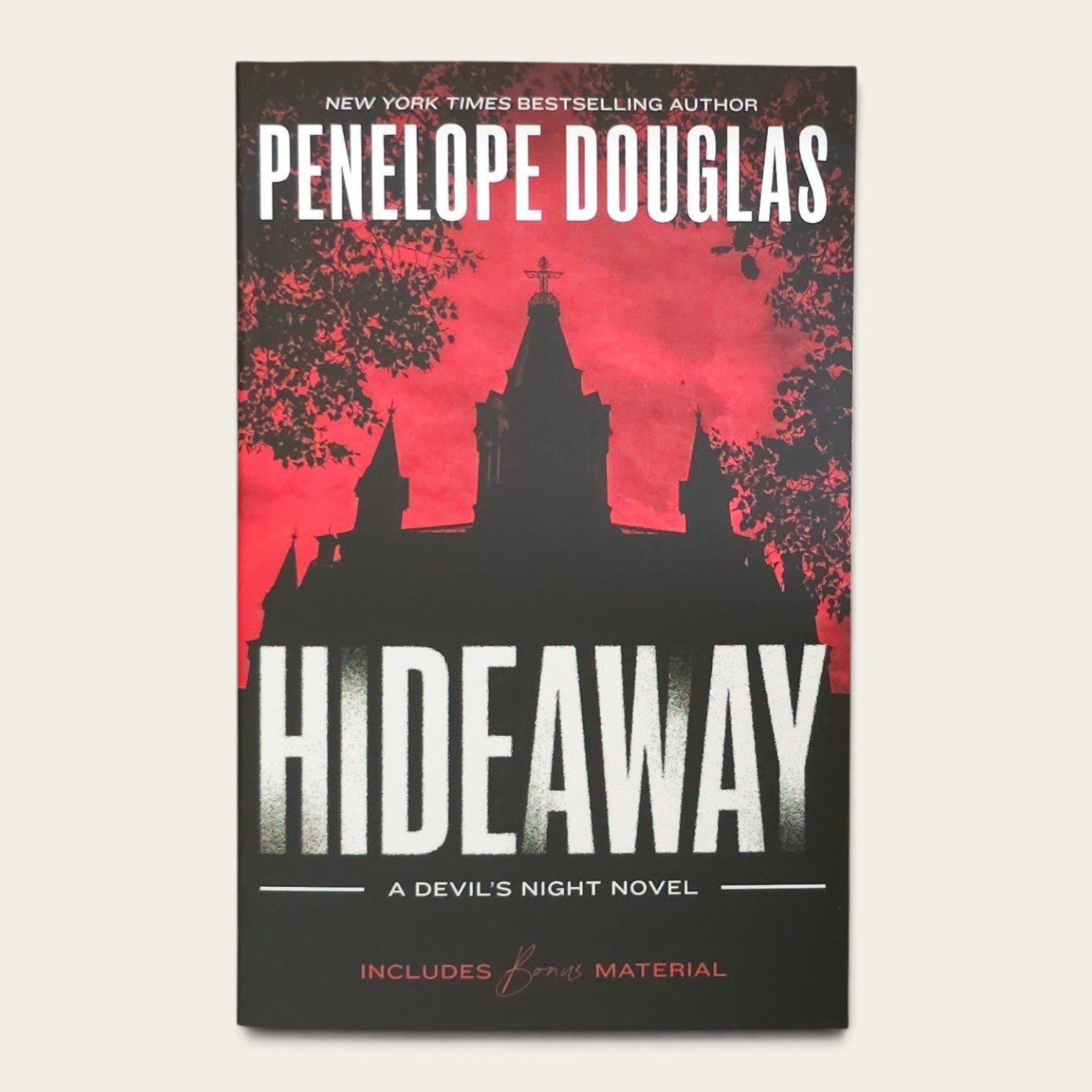 Book cover for 'Hideaway' by Penelope Douglas, featuring a black silhouette of a gothic cathedral against a vivid red sky, with large white title text and a black lower section.