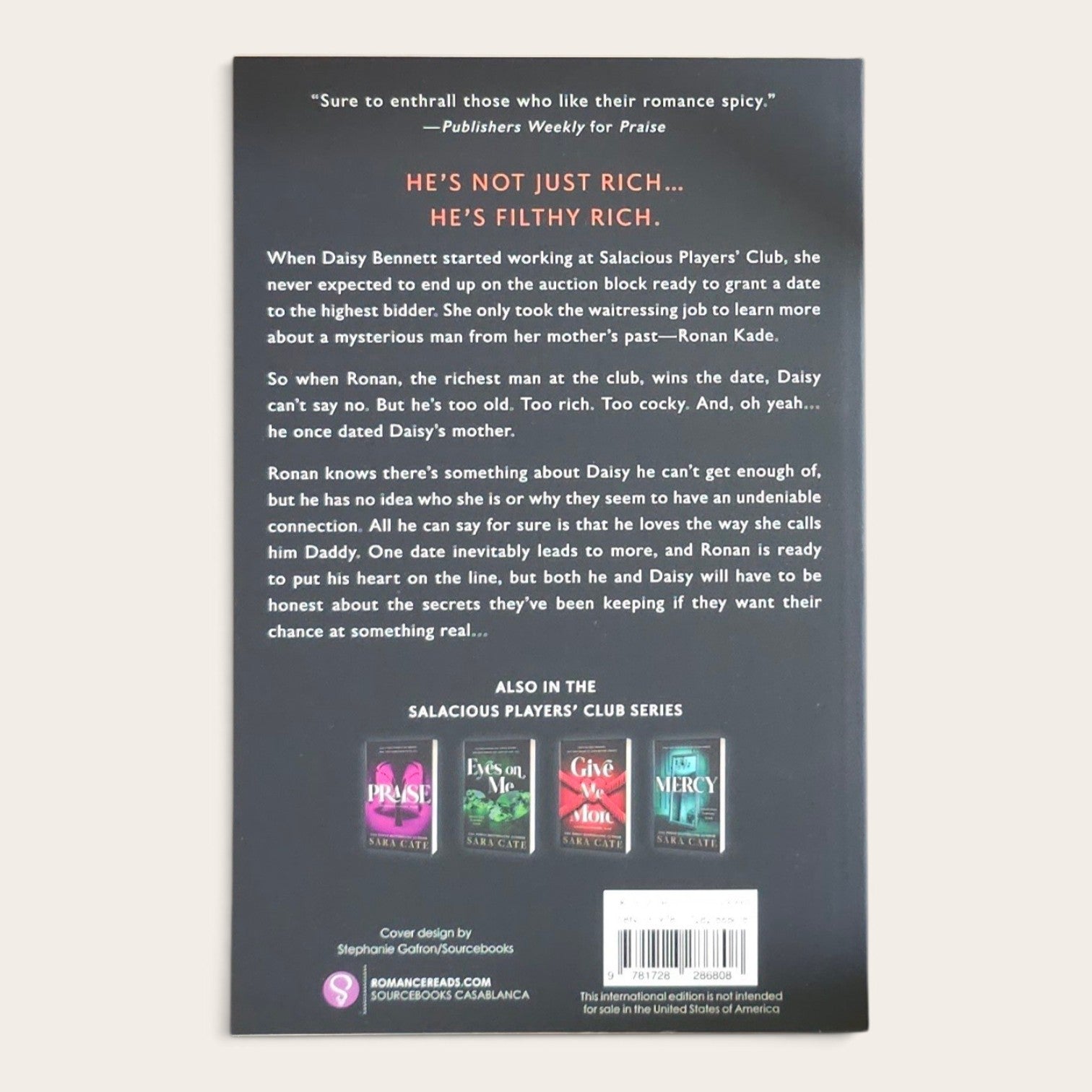 The back cover of a romance novel book, featuring a dark gray background with white and orange text, three colorful book cover previews, and a barcode at the bottom.
