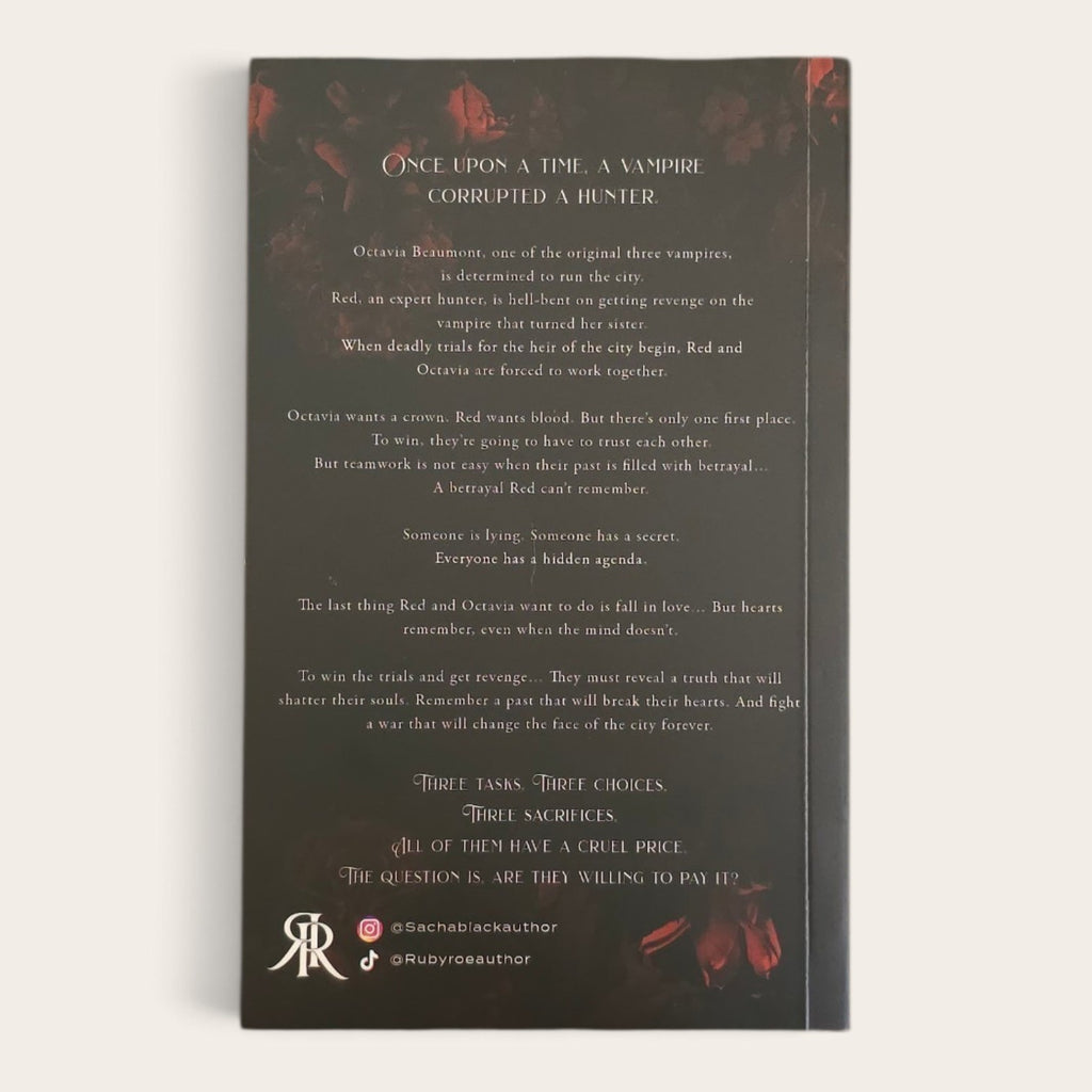 A book with a dark charcoal background and red floral accents, photographed against a light neutral background. The front features text 'Once Upon a Time a Vampire Corrupted a Hunter' with multiple stanzas and small red decorative elements near the top and bottom corners.