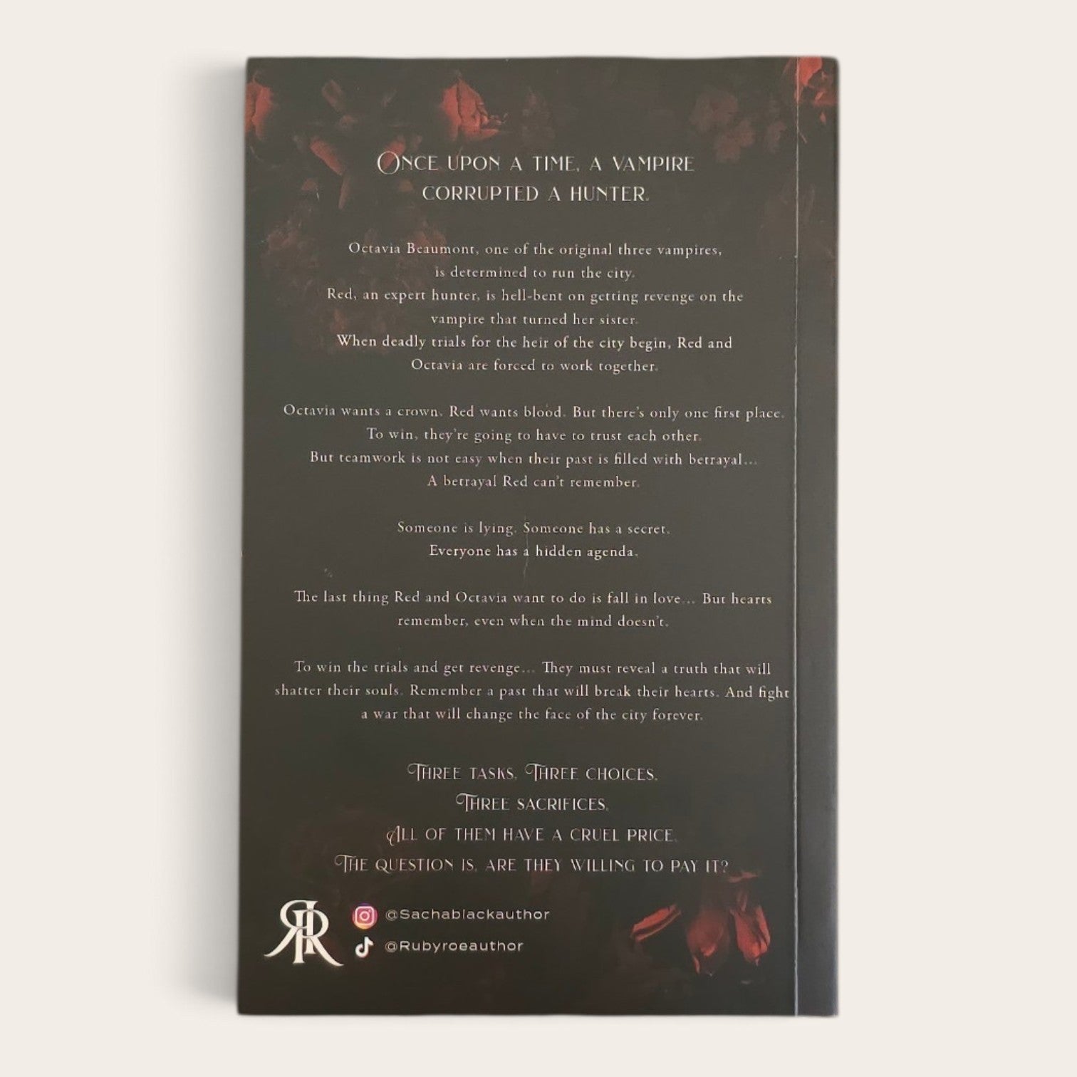 A book with a dark charcoal background and red floral accents, photographed against a light neutral background. The front features text 'Once Upon a Time a Vampire Corrupted a Hunter' with multiple stanzas and small red decorative elements near the top and bottom corners.