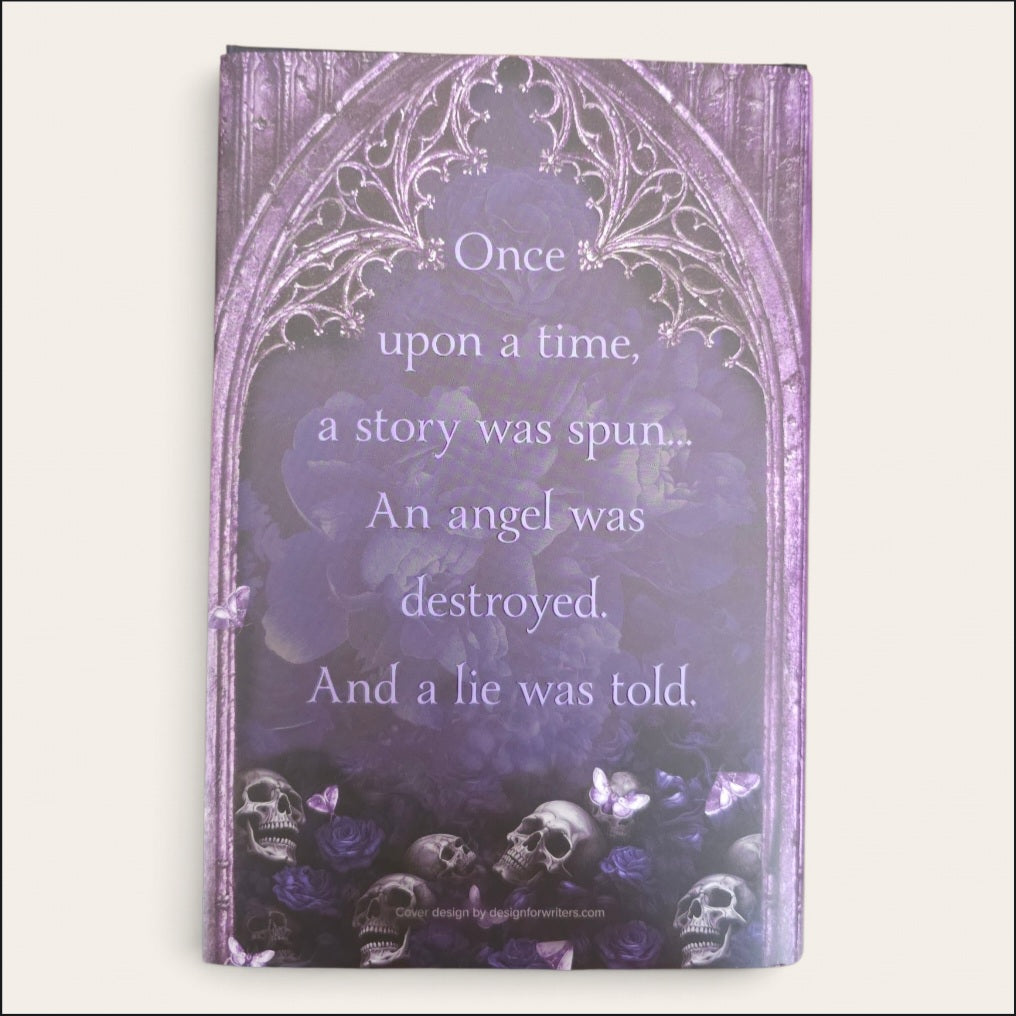 A book featuring a gothic purple design with an arched border, white decorative filigree, a quote about an angel and a lie, skulls, and butterflies at the bottom, shown against a light neutral background.