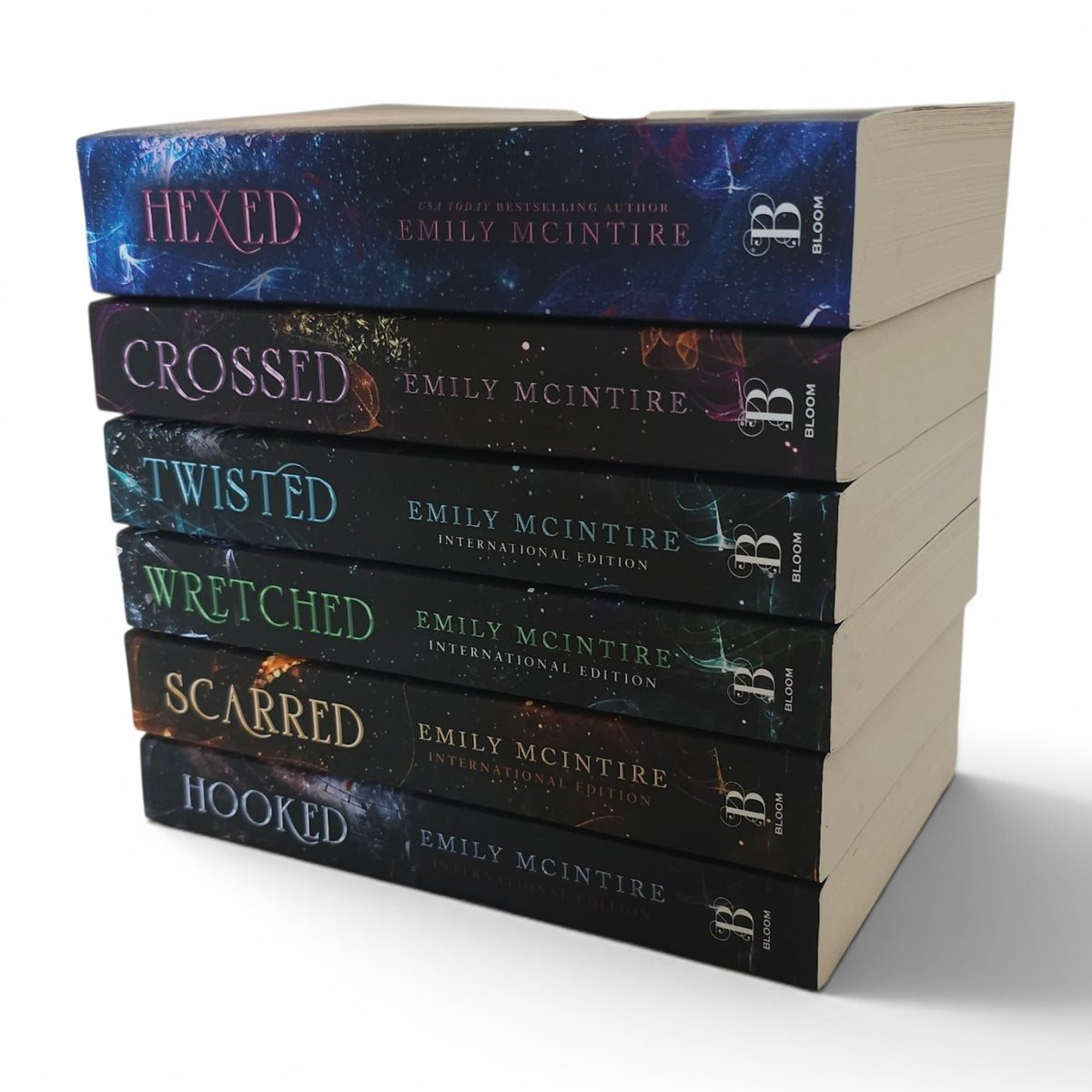 A stack of six romance novels by Emily McIntire, including Hexed, Crossed, Twisted, Wretched, Scarred, and Hooked, in Bloom Books International Edition paperback covers, shown on a white background.