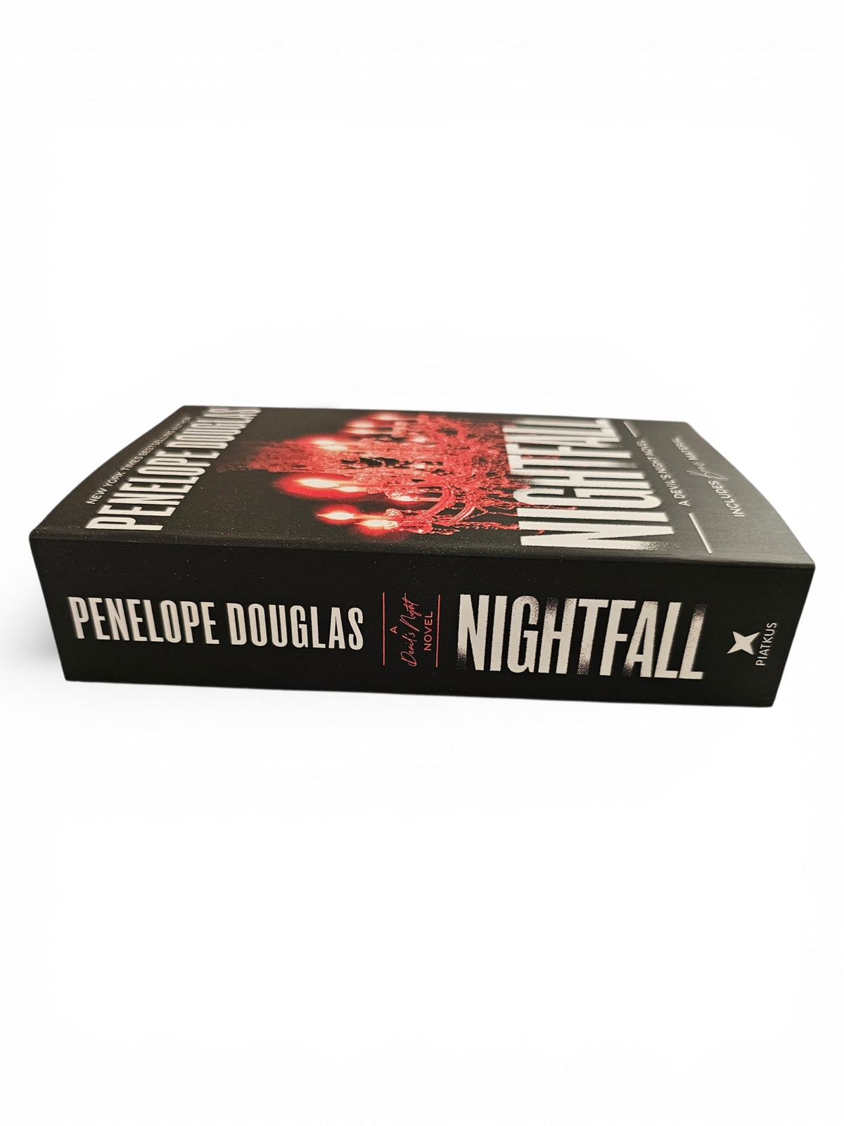 The book 'Nightfall' by Penelope Douglas, featuring a black cover with a red abstract graphic and bold white title text, photographed on a clean white background.