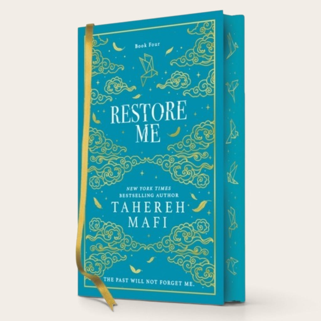 A hardcover book titled 'Restore Me' by Tahereh Mafi, featuring a bright teal cover decorated with gold celestial and cloud illustrations, a gold ribbon bookmark, and a matching teal spine, set against a light beige background.