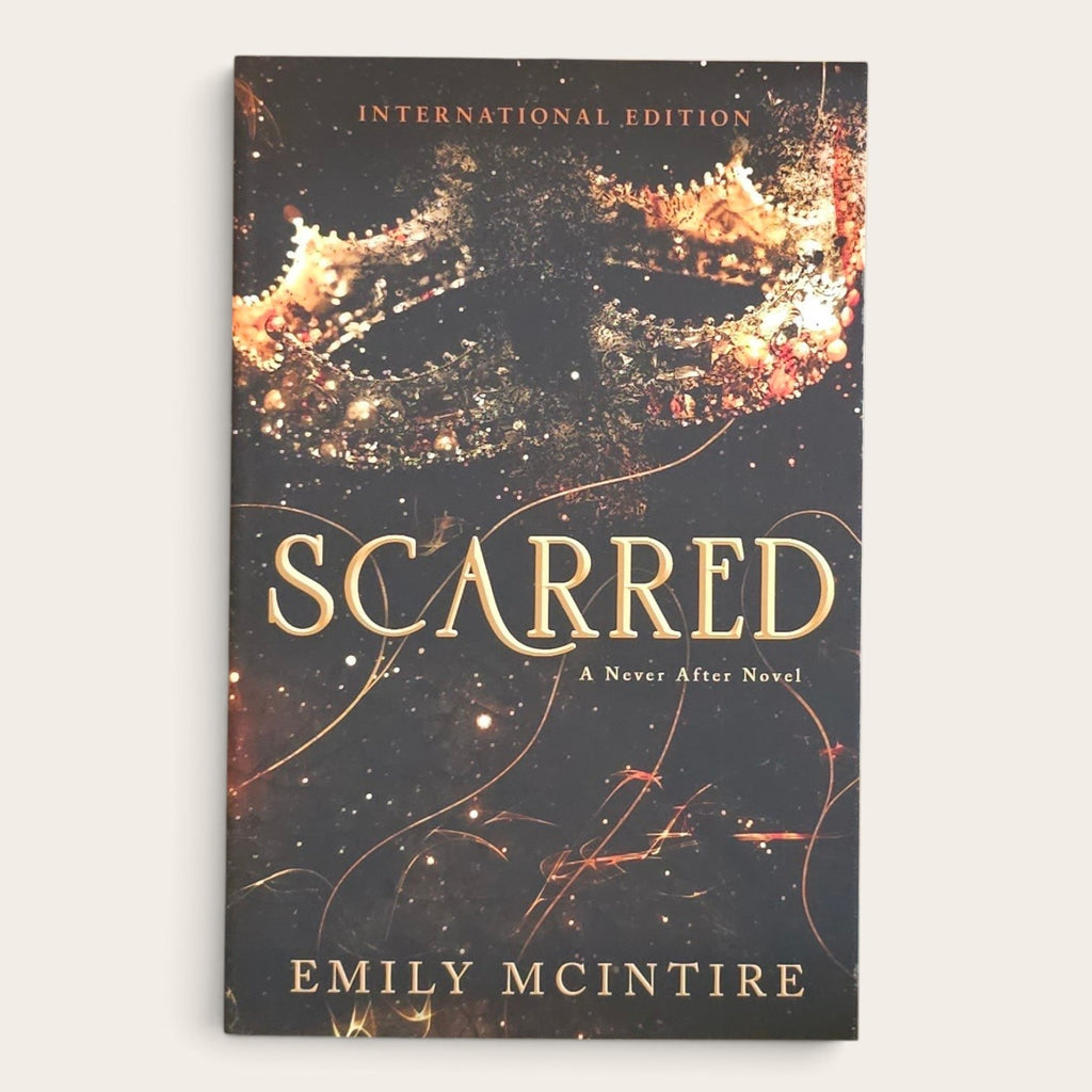 The front cover of the book 'Scarred: A Never After Novel' by Emily McIntire, shown as an International Edition paperback against a light beige background.