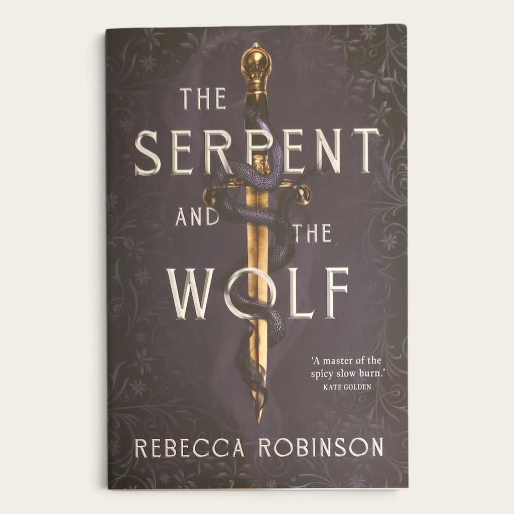 The book cover of 'The Serpent and the Wolf' by Rebecca Robinson, featuring a dark brown background with ornate floral patterns, a gold sword, and a dark serpent wrapping around it.