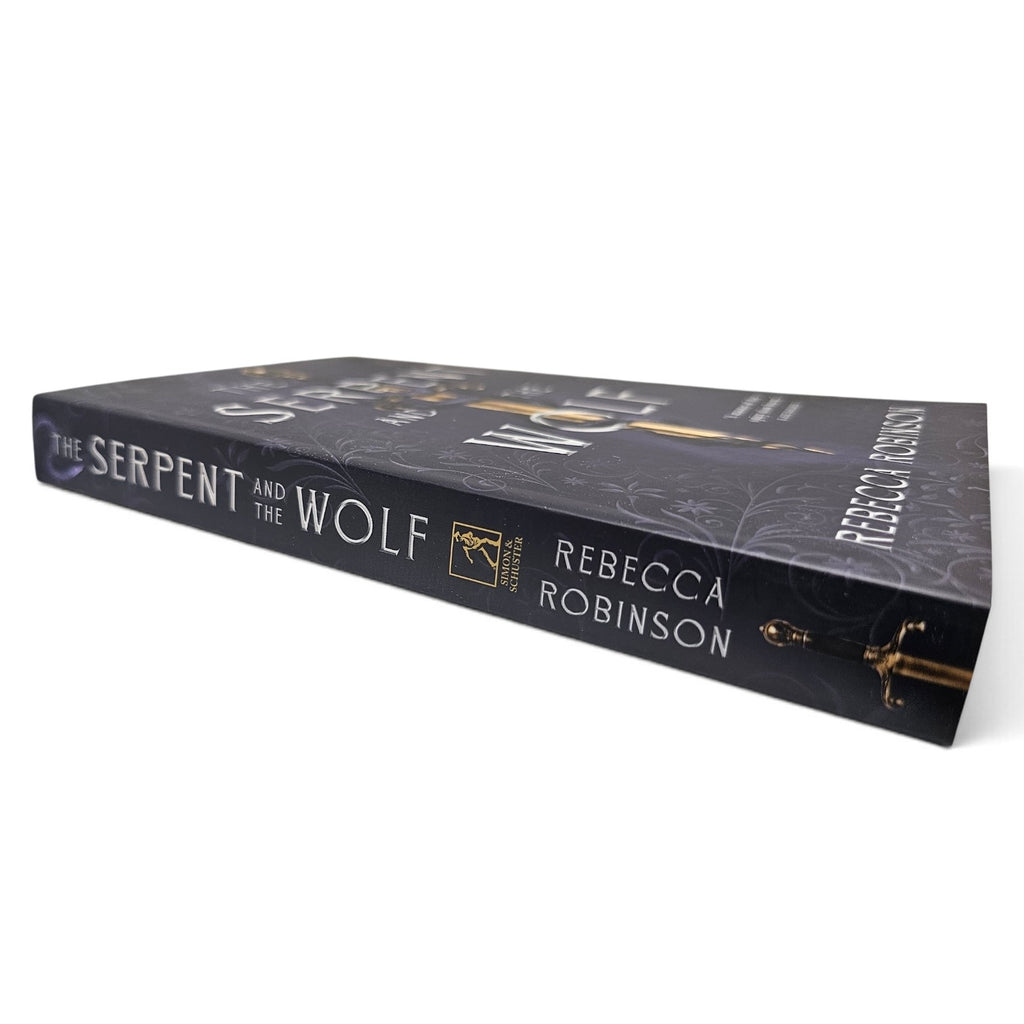 A paperback book titled 'The Serpent and the Wolf' by Rebecca Robinson, shown at an angle on a clean white background. The book cover is a very dark purple with gold and white text and illustrations.