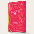 Book cover for 'Unravel Me' by Tahereh Mafi, featuring a bright pink cover with gold floral line art and white text, shown with a gold ribbon bookmark against a light beige background.